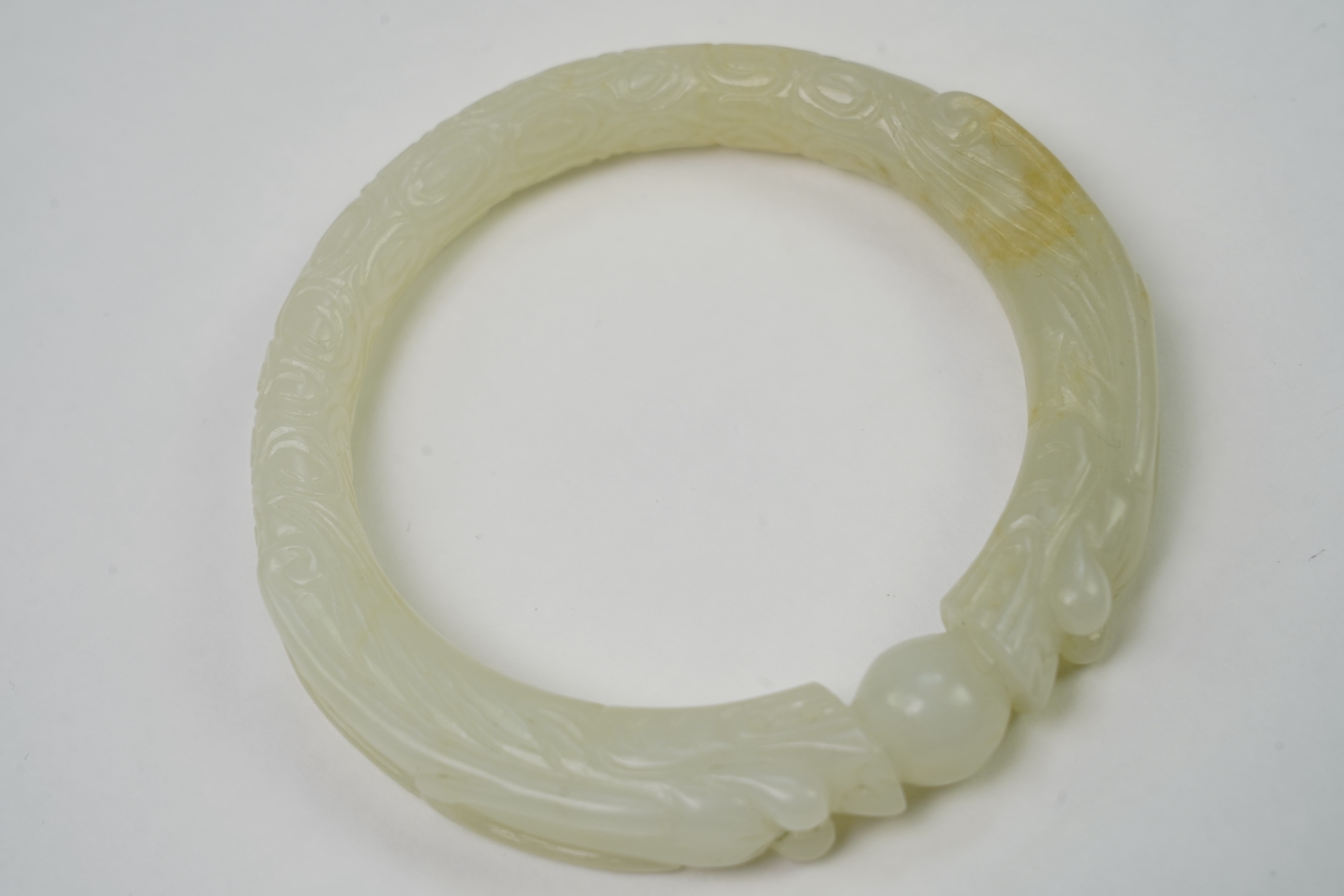 A Chinese pale celadon jade ’dragon’ bangle